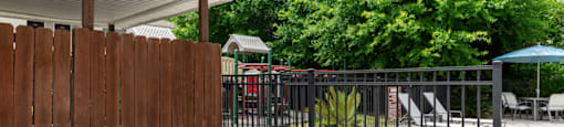 a backyard with a fence and barbecue grill
