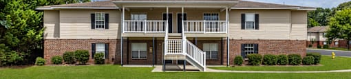 an apartment building with a porch and a staircase