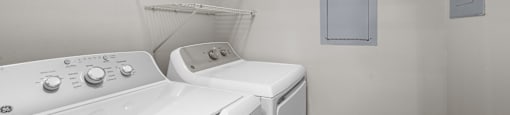 a washer and dryer in a laundry room with a shelf on the wall