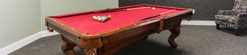 a game room with a pool table and a clock on the wall