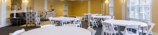 a room with yellow walls and white tables and chairs