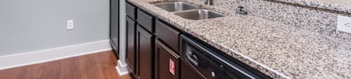 a kitchen with granite countertops and a black refrigerator