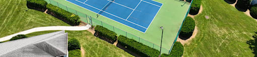 an aerial view of a tennis court in a parking lot