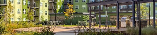 A walkway leads through a grassy area in front of apartment buildings at Boardwalk at Research Park apartments in Huntsville, AL.