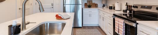 A modern kitchen with a stainless steel refrigerator and black oven.