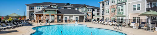 a large swimming pool in front of an apartment building