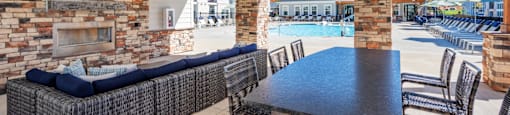 the clubhouse with a pool and a table with chairs and a tv