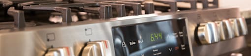 A stainless steel gas stove with a digital display at 27Seventy Lower Heights apartments in Houston, TX.