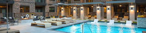 A large apartment building with a pool in front at 27Seventy Lower Heights apartments in Houston, TX.