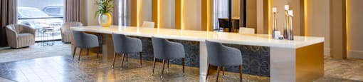 A reception area with a long table and chairs at 27Seventy Lower Heights apartments in Houston, TX.