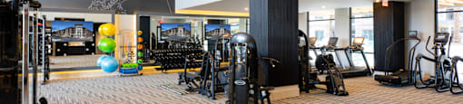 A gym with a variety of equipment including treadmills, weights, and exercise balls at 27Seventy Lower Heights apartments in Houston, TX.