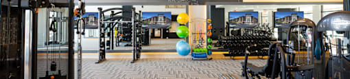 A gym with a variety of equipment including treadmills, weights, and exercise machines at 27Seventy Lower Heights apartments in Houston, TX.