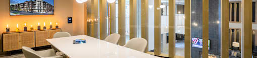 A conference room with a long table and chairs at 27Seventy Lower Heights apartments in Houston, TX.