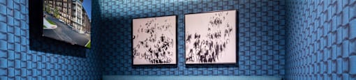 A blue couch with a white table in front of it and two pictures on the wall at 27Seventy Lower Heights apartments in Houston, TX.