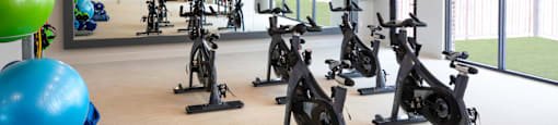 A gym with exercise bikes and exercise balls at 27Seventy Lower Heights apartments in Houston, TX.