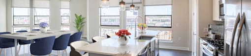 A modern kitchen with a dining table and chairs at 27Seventy Lower Heights apartments in Houston, TX.