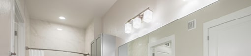 A bathroom with a marble style shower and tub  combo and sink at 27Seventy Lower Heights apartments in Houston, TX.