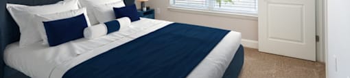 A bedroom with a large bed and a blue abstract painting on the wall.