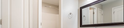 a bathroom with white cabinets and a mirror and a toilet