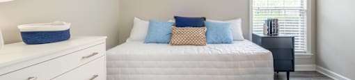 a bedroom with a bed and a dresser in a 555 waverly unit