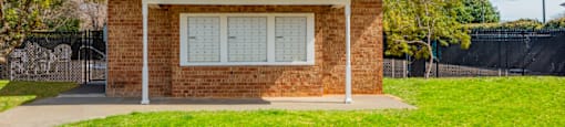 a small brick building with a lawn in front of it