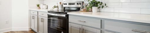 A kitchen with a black oven and a black microwave above it.