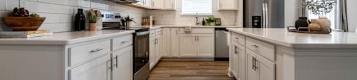 A modern kitchen with white cabinets and wooden floors.