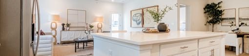 A kitchen with white cabinets and a wooden floor.