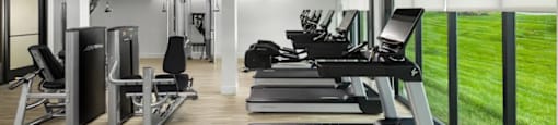 A gym with treadmills, weights, and exercise equipment at Boardwalk at Research Park apartments in Huntsville, AL.