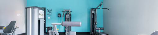 a gym with exercise equipment and a blue wall