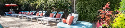 A patio with a pool and a table with chairs.