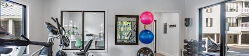 a home gym with exercise equipment and a ceiling fan