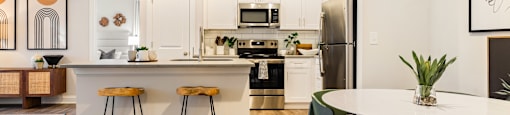 an open kitchen and dining area with a table and stools