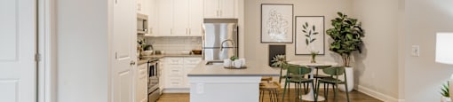 an open kitchen and living room with a dining area and a table with chairs