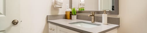 a white bathroom with a sink and a mirror