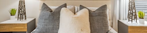 a bedroom with a bed with pillows and a wooden headboard