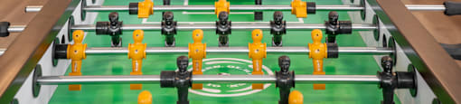 a foosball table in a living room with a pool table