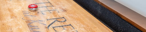 a shuffleboard table in a room with the name of the company on it