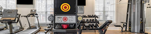 a gym with weights and a screen in the center of it