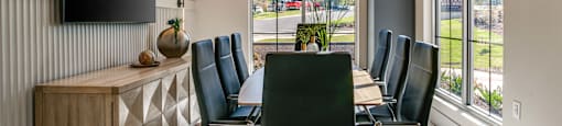 a conference room with a table and chairs and a tv