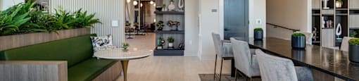 a communal area with a bar and chairs and a kitchen and dining room