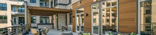 the private patio of an apartment building with furniture and a table