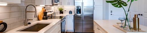 a kitchen with white cabinets and a stainless steel refrigerator
