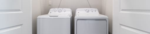 a washer and dryer in a laundry room at the oxford at estonia apartments
