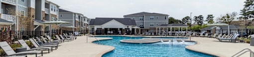 a resort style swimming pool with lounge chairs around it