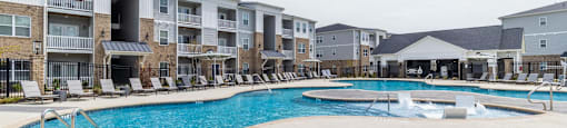 a large swimming pool with an apartment building in the background