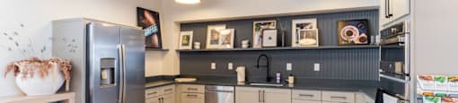 a kitchen with gray cabinets and stainless steel appliances