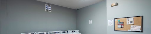 a laundry room with washers and dryers in it and a table with laundry