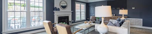 a living room with a white couch and chairs and a fireplace