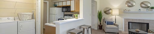 a living room with a kitchen and a bar with stools